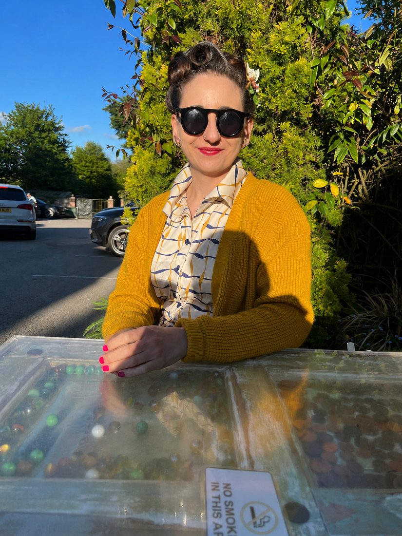 Holly Walton outdoors in a yellow cardigan